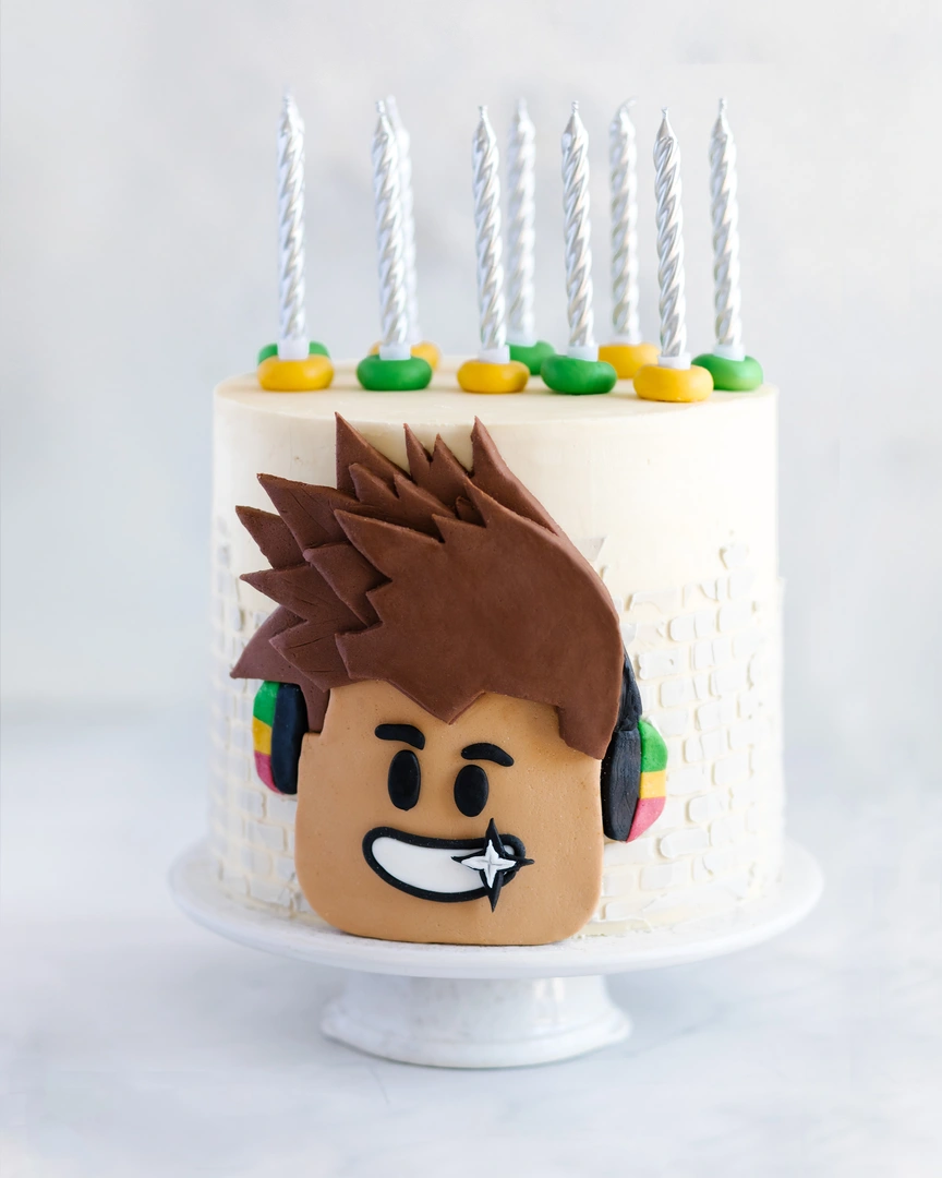 Стабилен крем за тортата. На светла керамична поставка стои торта, украсена със свещи. На повърхността на тортата като декор се използва снимка на усмихнат млад мъж.