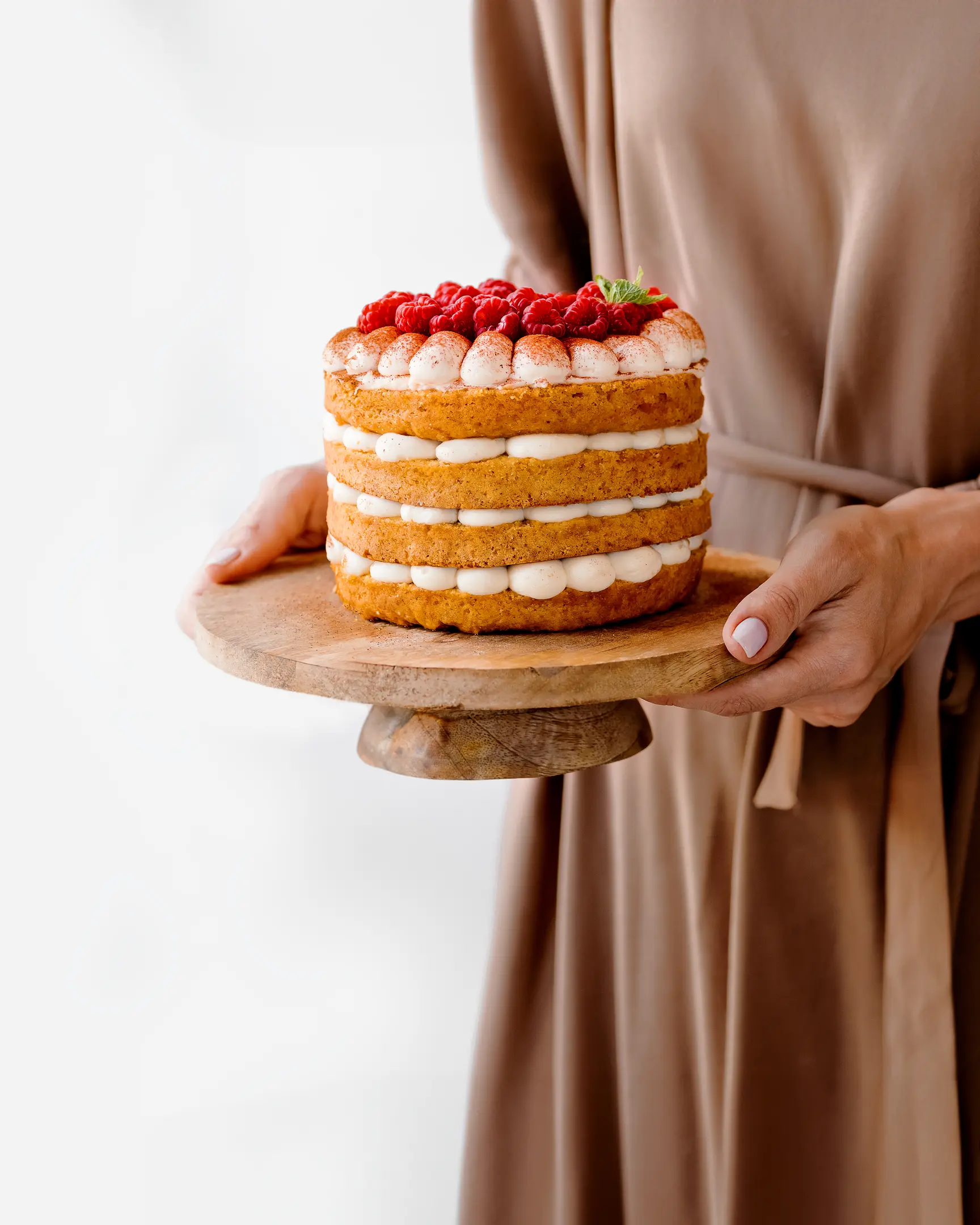 Жена, която държи чиния с торта в ръцете си. Жена, която държи чиния с торта в ръцете си. Торта, украсена с ягоди