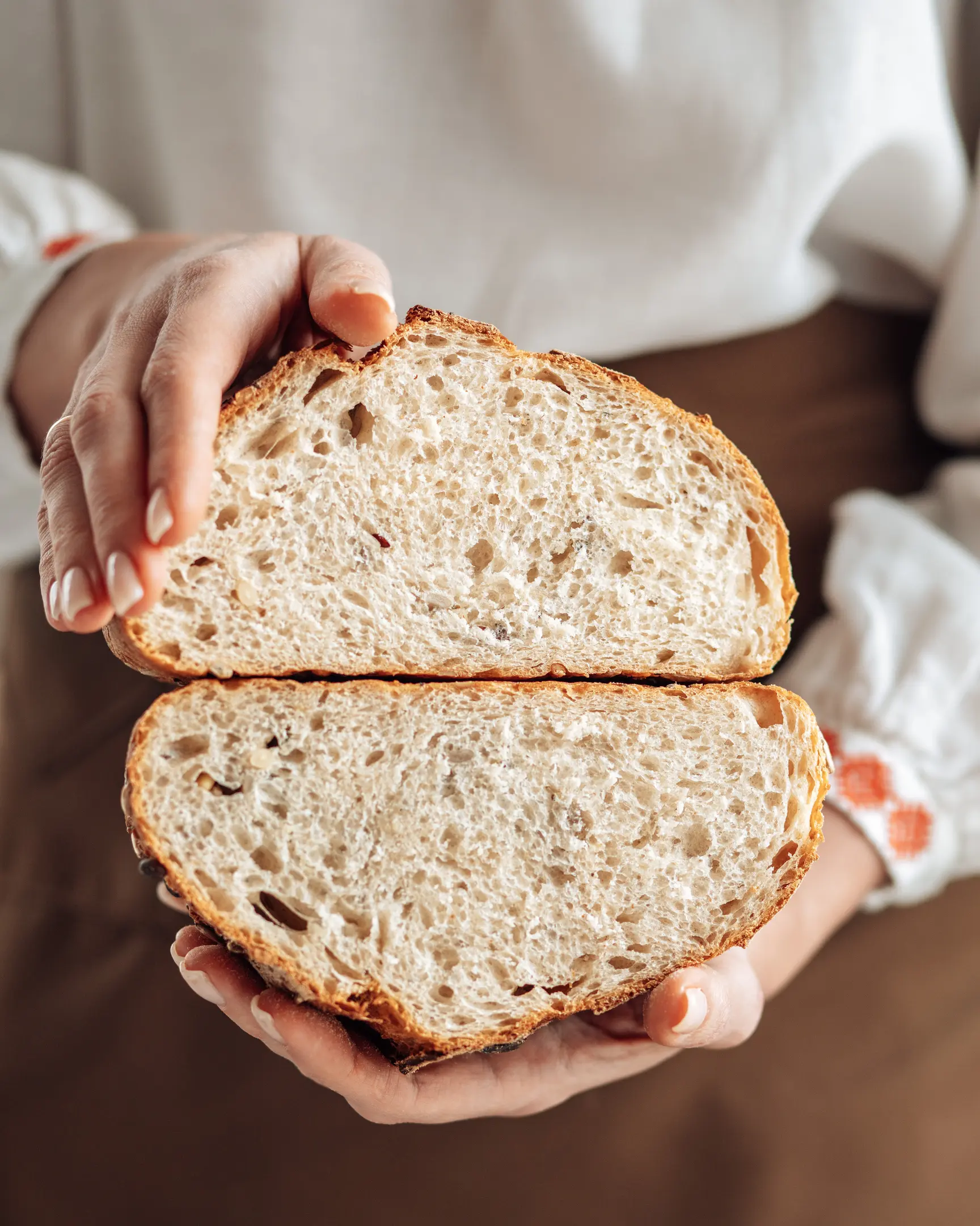 Жена, която държи в ръцете си нарязан хляб. Жена, която държи хляба в ръцете си.