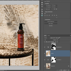 Ретуширане. Фотограф използва приложение на Adobe Photoshop, за да коригира снимка на бутилка серум (или шампоан). Той е на маса и сянка от палмово листо зад него.